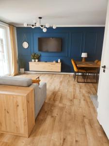 sala de estar con paredes azules, cama y mesa en Miodowy Apartament, en Złotów
