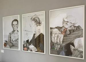 three framed drawings of a man and a woman on a wall at Chez Nous in Capoliveri