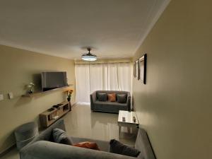 a living room with two couches and a tv at Apto Entero familiar espacioso con piscina confortable in Licey