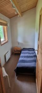 una camera con un letto blu e una sedia di Fin stuga nära sjö a Bollnäs