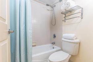 une salle de bain avec des toilettes blanches et une douche dans l'établissement Daytona Beach Resort Oceanfront 1 Bedroom Suite, 2 Queen Beds, à Daytona Beach 15 autres photos