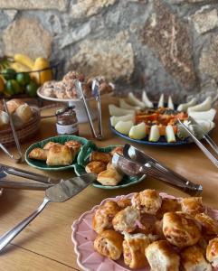 a table topped with plates of food and appetizers at Pousada Villa Tiradentes in Tiradentes