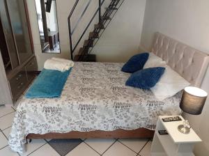 a bedroom with a bed with blue pillows and a staircase at Private Guest House in Lima