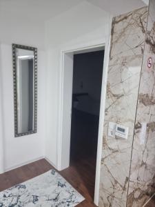 a bathroom with a mirror next to a door at Apartments FOUR SEASONS in Sarajevo