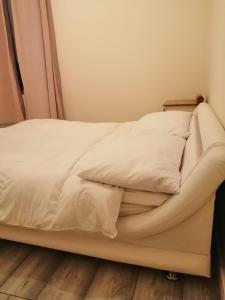 a bed with white sheets and pillows on it at Angelica place in Portsmouth