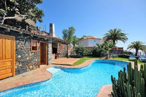 eine Villa mit einem Pool und einem Haus in der Unterkunft Las Palmeras A in Arecida