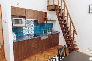 a kitchen with wooden cabinets and a spiral staircase at Kraków Wawel Zwierzyniecka in Krakow