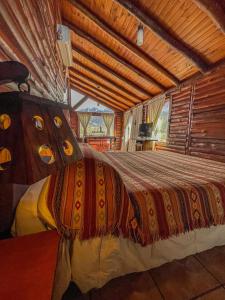 Cama grande en habitación con ventana grande en Cabañas Aventurados en Potrerillos