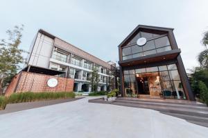 un edificio con un reloj en la parte delantera en Phu sakon ville hotel, en Ban Phang Khwang Tai