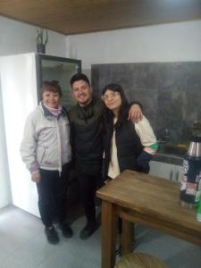 three people posing for a picture in a kitchen at Alojamiento Mana in Malargüe