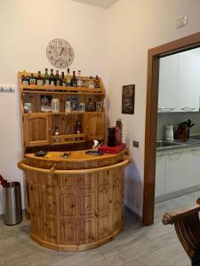 a bar in a kitchen with a clock on the wall at Appartamento Michelangelo in Novara