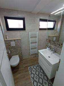 a bathroom with a white sink and a toilet at Apartman Nina in Tuzla