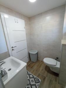 a bathroom with a white sink and a toilet at Apartman Nina in Tuzla