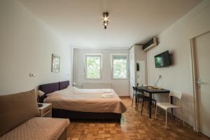 a bedroom with a bed and a table and a couch at Arena East Apartment in Belgrade