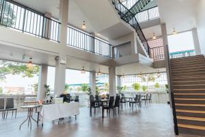 a restaurant with tables and chairs and a staircase at Phu sakon ville hotel in Ban Phang Khwang Tai