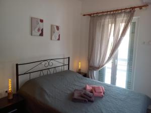 um quarto com uma cama com duas toalhas cor-de-rosa em Trizina's Guesthouse 