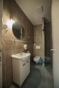a bathroom with a sink and a toilet and a mirror at Arena East Apartment in Belgrade