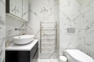 a white bathroom with a sink and a toilet at 3 Bedroom flat with Terrace in Central London in London