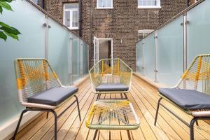 three chairs and a table on a balcony at 3 Bedroom flat with Terrace in Central London in London