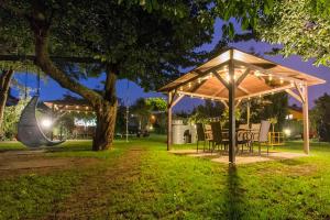 - un pavillon avec des chaises et une table dans un parc la nuit dans l'établissement Willa Rodos II, à Władysławowo