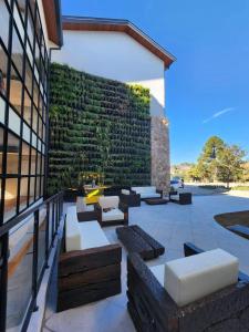a patio with couches and a green wall at Quarto no Wanderlust Experience Hotel in Campos do Jordão