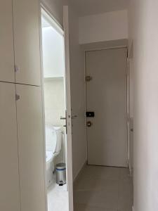 een witte badkamer met een toilet en een deur bij studio paris 12 in Parijs