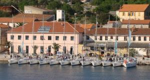 un grupo de barcos atracados en el agua cerca de un edificio en Apartments Orlić, en Sali