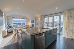 a kitchen and living room with a view of the ocean at Southland Sounds - Te Anau Holiday Home in Te Anau