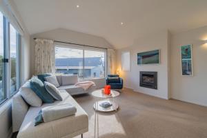 a living room with a couch and a fireplace at Southland Sounds - Te Anau Holiday Home in Te Anau
