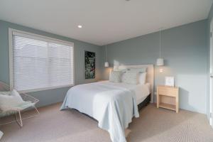 a bedroom with a white bed and a window at Southland Sounds - Te Anau Holiday Home in Te Anau