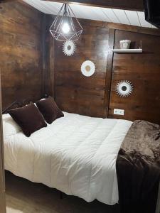 1 dormitorio con 1 cama con pared de madera en Finca con dos casas rurales, en Randufe