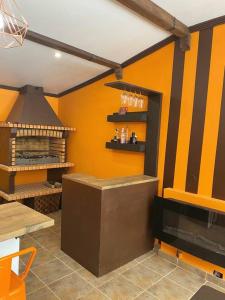 cocina con pared de color naranja y fogones en Finca con dos casas rurales, en Randufe