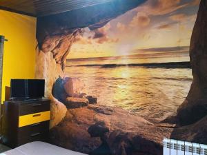 a bedroom with a painting of the ocean on the wall at Finca con dos casas rurales in Randufe