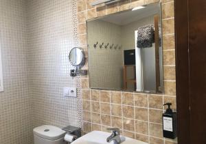 La salle de bains est pourvue d'un lavabo, d'un miroir et de toilettes. dans l'établissement Casa Rural Relax & Nature, à Prado del Rey