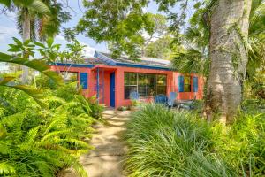 a colorful house in the middle of a forest at Colorful Gulfport Home Walk to the Art District! in St Petersburg