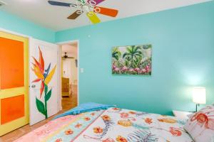 a bedroom with a bed and a ceiling fan at Colorful Gulfport Home Walk to the Art District! in St. Petersburg