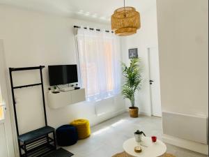 un salon avec une chaise et une télévision dans l'établissement Le Repère de B&C, à Cenon