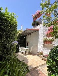 a patio with a table and chairs and flowers at Trulli MADIA Luxury Alberobello in Alberobello