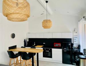a kitchen with a wooden table and black appliances at Le Repère de B&C in Cenon