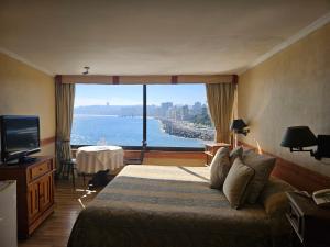 una camera d'albergo con un letto e una grande finestra di Hotel Restaurant CapDucal a Viña del Mar