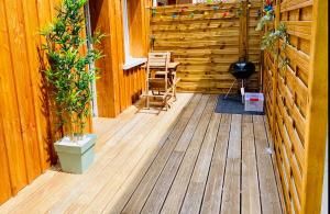 une terrasse en bois avec deux chaises et un grill dans l'établissement Le Repère de B&C, à Cenon
