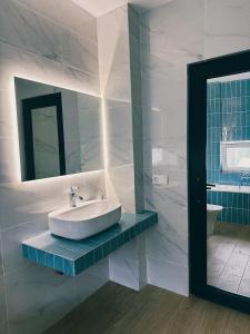 Baño blanco con lavabo y espejo en LIMANI, en Grigoleti