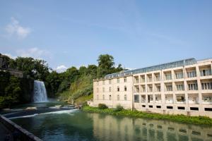 a building next to a river with a waterfall at Il balcone di Angelina in Isola del Liri