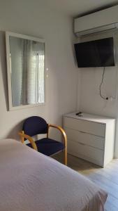 sypialnia z łóżkiem, telewizorem i krzesłem w obiekcie Habitación independiente céntrica w mieście Fuengirola