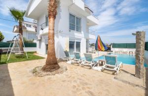 een villa met een zwembad en een palmboom bij Dazzling Villa with Private Pool in Antalya in Belek