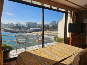 a bedroom with a bed and a view of the ocean at Hotel Restaurant CapDucal in Viña del Mar
