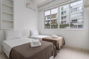 1 dormitorio con 2 camas y ventana en Conforto em Copacabana - Feito para famílias - RP602 Z4, en Río de Janeiro