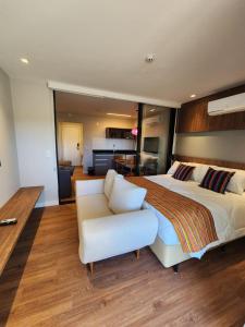 a large bedroom with a large bed and a couch at Quarto no Wanderlust Experience Hotel in Campos do Jordão