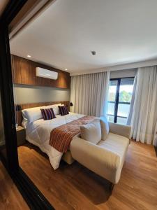 a large bedroom with a bed and a couch at Quarto no Wanderlust Experience Hotel in Campos do Jordão