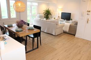 a living room with a table and a couch at Junto a las playas,dos terrazas y vistas al mar in Sopelana +41 photos
